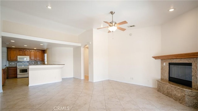 unfurnished living room featuring recessed lighting, visible vents, a ceiling fan, light tile patterned floors, and a premium fireplace