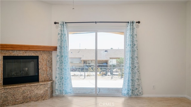 doorway to outside featuring a premium fireplace and light tile patterned flooring