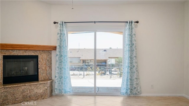 entryway featuring baseboards, tile patterned flooring, and a premium fireplace