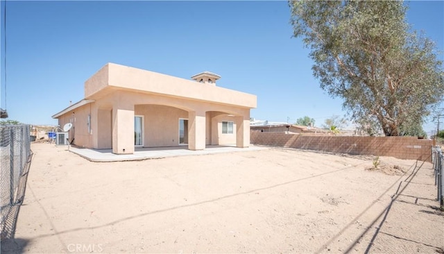 rear view of house featuring a patio, a fenced backyard, and stucco siding