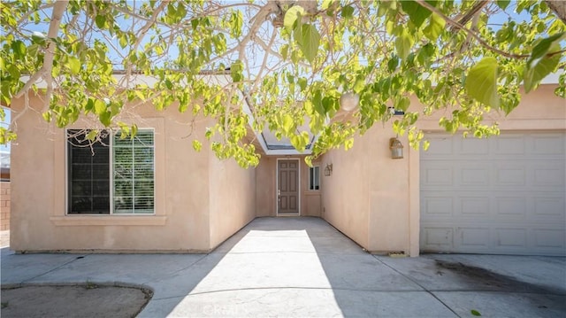 entrance to property featuring stucco siding and an attached garage