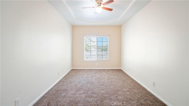 unfurnished room featuring baseboards, carpet floors, a raised ceiling, and ceiling fan