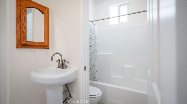 bathroom featuring shower / tub combo and toilet