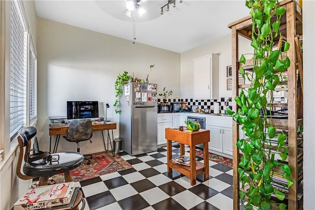 kitchen with ceiling fan, stainless steel fridge, sink, and white cabinetry