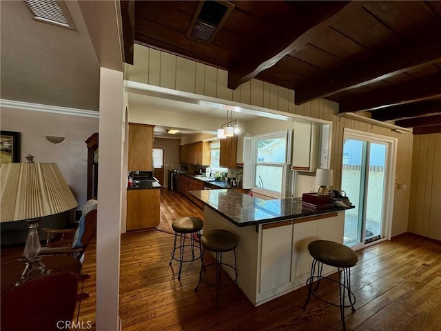 kitchen featuring wooden ceiling, a breakfast bar, beamed ceiling, and hardwood / wood-style floors