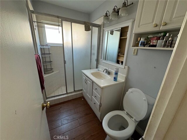 bathroom featuring vanity, walk in shower, and toilet