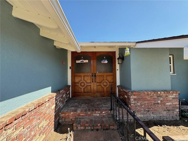 property entrance featuring brick siding and stucco siding