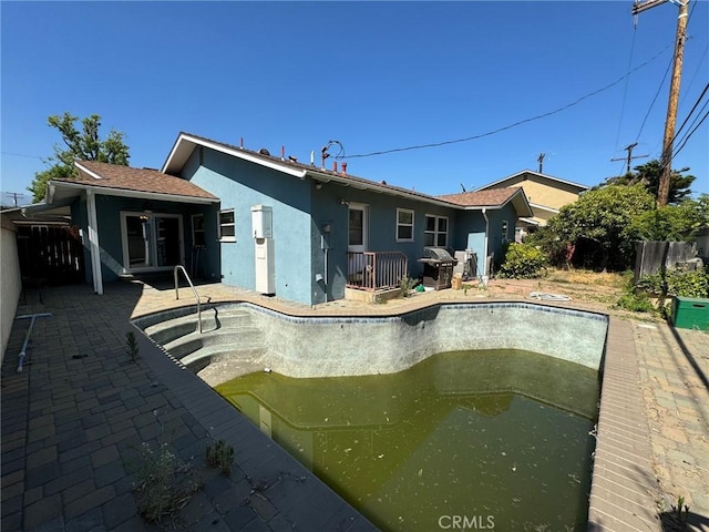 back of house featuring a patio area and a fenced in pool