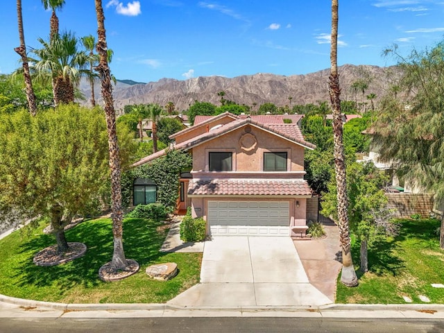 view of front of property featuring a mountain view, a front lawn, and a garage