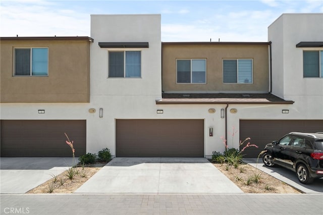 3570 E Peckham Paseo Unit 3, Ontario, CA 91761 - view of property with an attached garage, stucco siding, and driveway
