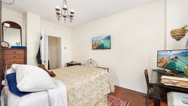 bedroom with an inviting chandelier and dark wood-type flooring