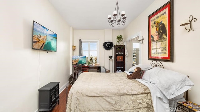 bedroom featuring dark hardwood / wood-style flooring and a chandelier