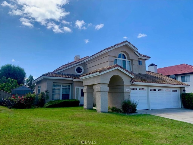 mediterranean / spanish-style home with a garage and a front yard