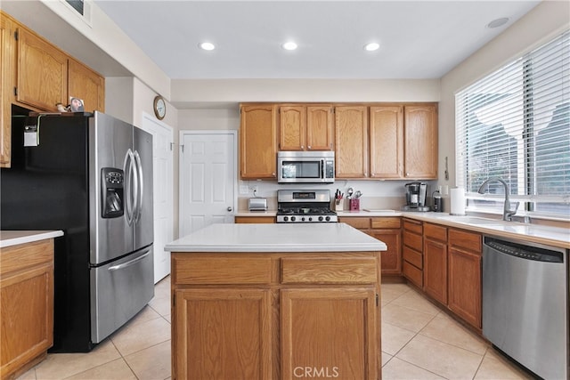 kitchen featuring light tile patterned floors, stainless steel appliances, a kitchen island, and sink