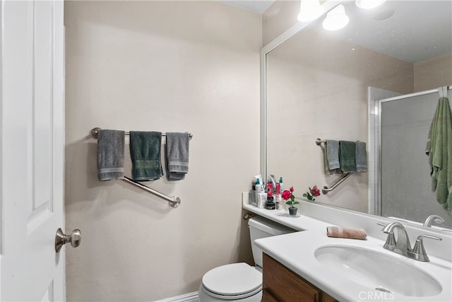 bathroom featuring vanity, toilet, and a shower with shower door