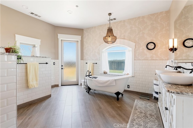 bathroom with vanity, hardwood / wood-style floors, tile walls, and a bathing tub