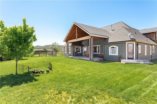 rear view of property featuring a patio area and a lawn