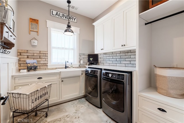 laundry area with cabinets, washer and dryer, and sink