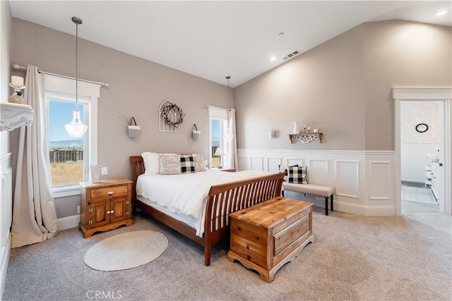 bedroom with lofted ceiling and light colored carpet