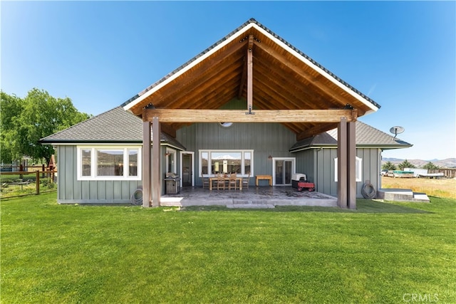 rear view of property with a patio and a lawn