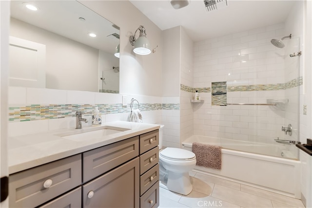 full bathroom featuring toilet, tile walls, tiled shower / bath, vanity, and tile patterned flooring