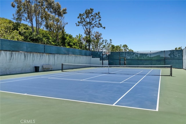 view of tennis court featuring basketball hoop