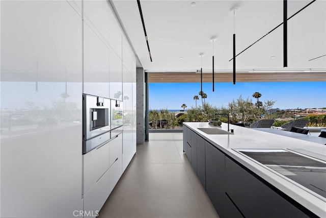 kitchen with white cabinetry, sink, and pendant lighting