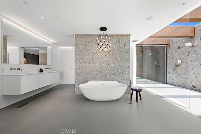 bathroom featuring vanity, a washtub, and concrete floors