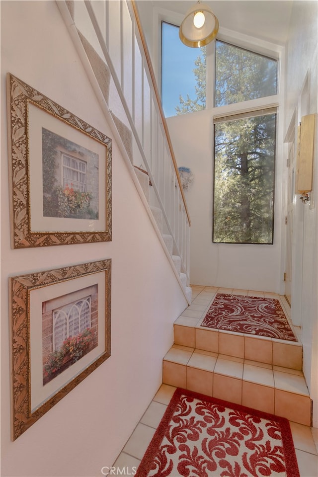 stairway featuring vaulted ceiling and tile patterned floors