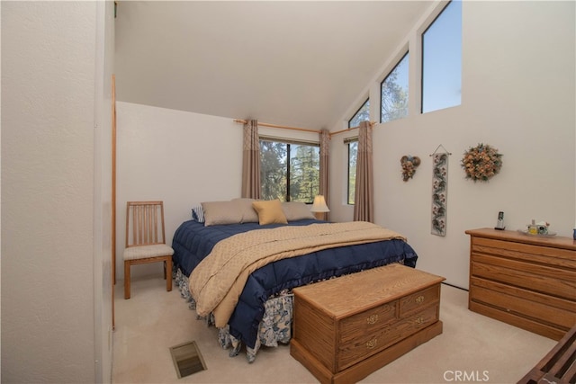 carpeted bedroom with high vaulted ceiling