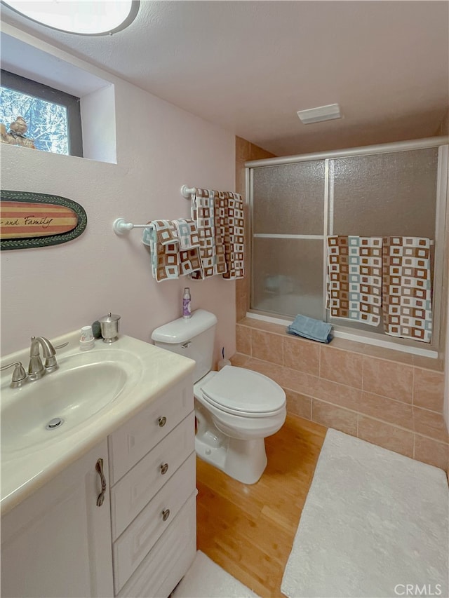 bathroom with wood-type flooring, vanity, and toilet