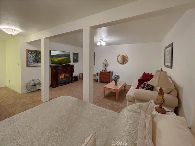 bedroom with light carpet and a fireplace