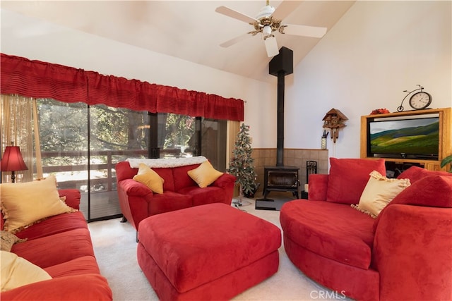 carpeted living room with lofted ceiling, ceiling fan, and a wood stove