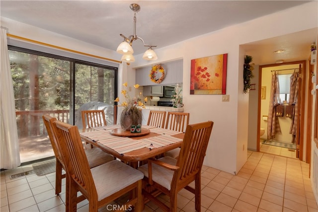 dining room featuring an inviting chandelier and light tile patterned floors