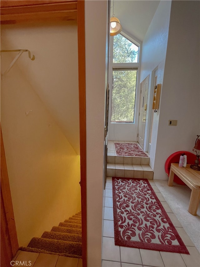 staircase with lofted ceiling and tile patterned flooring