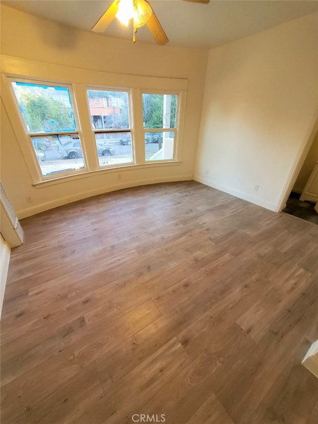 empty room with wood-type flooring and ceiling fan