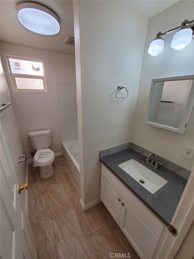 bathroom with vanity, toilet, and a washtub