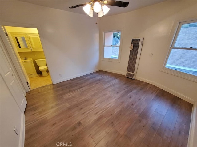 unfurnished bedroom with connected bathroom, ceiling fan, and wood-type flooring