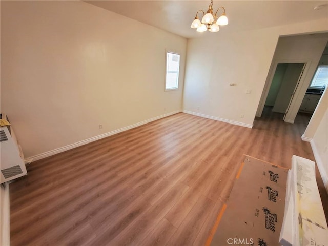 interior space with wood-type flooring and an inviting chandelier