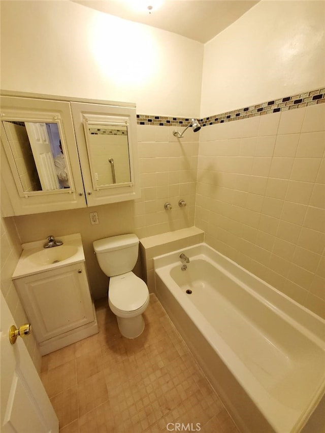 full bathroom with toilet, tiled shower / bath combo, and sink