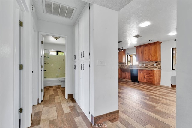 interior space with light wood-type flooring and a textured ceiling