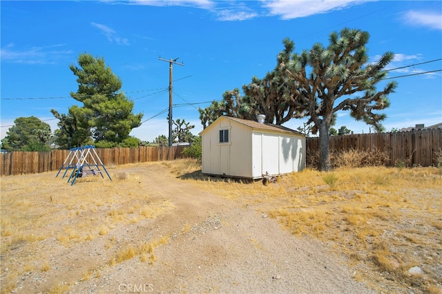 view of yard featuring a playground and a storage unit