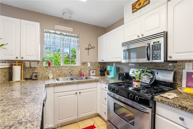 kitchen featuring white cabinets, range with gas cooktop, decorative backsplash, and sink