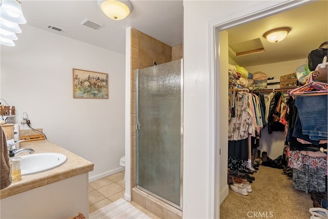 bathroom with vanity, toilet, tile patterned flooring, and walk in shower