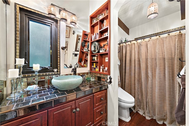 bathroom featuring curtained shower, hardwood / wood-style floors, vanity, and toilet