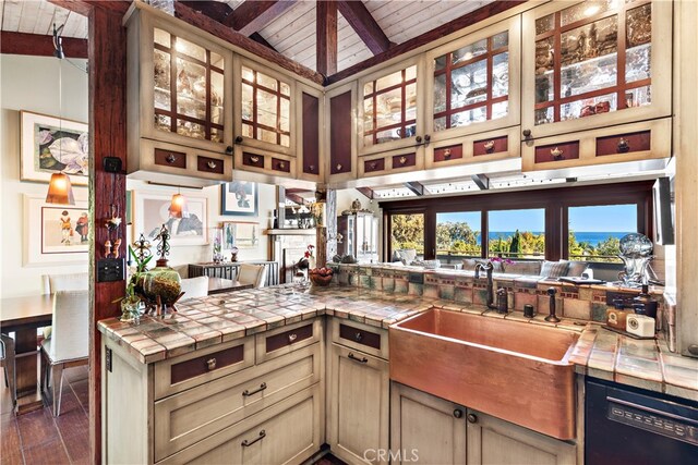 kitchen featuring a stone fireplace, tile countertops, lofted ceiling with beams, and wooden ceiling