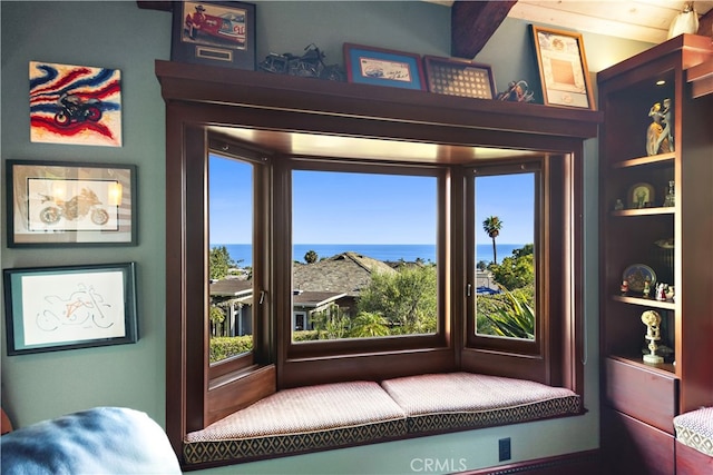 interior space with beam ceiling and a water view