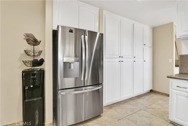 kitchen with white cabinets, dark stone countertops, and stainless steel fridge with ice dispenser