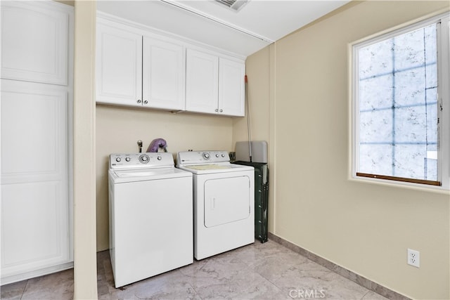 laundry area with washer and dryer and cabinets