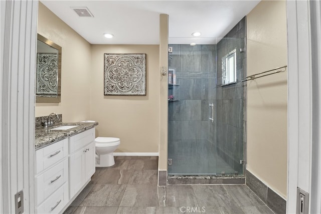 bathroom featuring toilet, a shower with shower door, and vanity